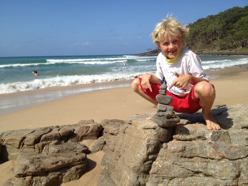 Alfie builds a rock sculpture on the beach at Tea Tree Bay