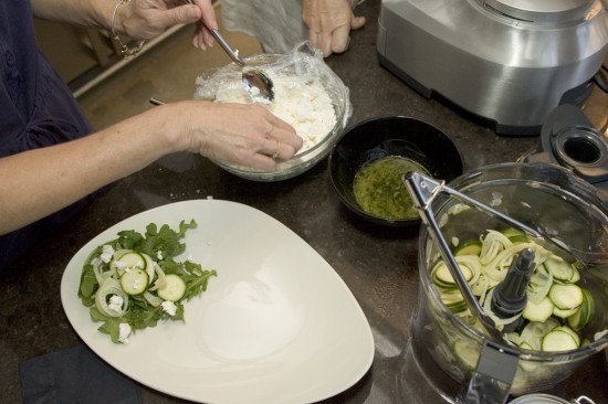 Plating the salad of fennel, zucchini, rocket, feta and pine nuts