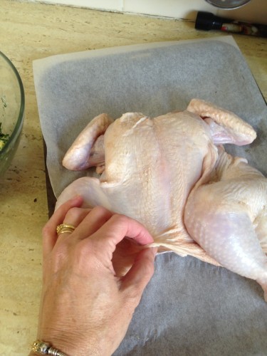 Delicately beginning to separate the skin from the breast