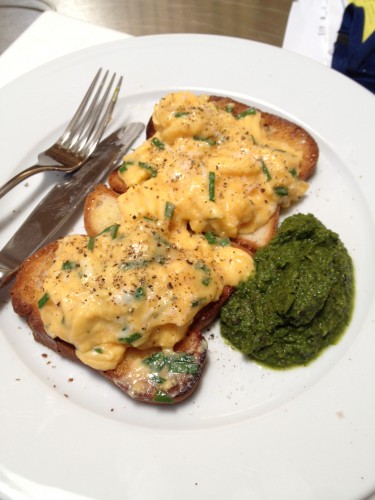 Scrambled eggs on two slices of toast with salsa verde