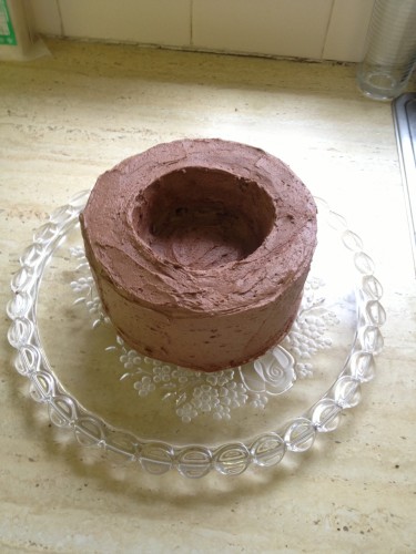 The hollowed out cake covered in chocolate butter cream