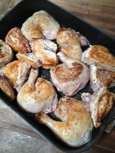 Browned chicken pieces lying all snug in the pan