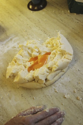 Adding the egg yolks to the dough
