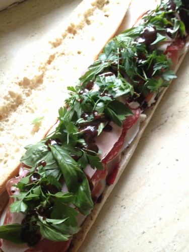 The ham, prosciutto and salami layers have been added, the herbs have been scattered and the dressing drizzled