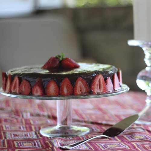 A gluten-free cake iced in ganache and decorated with strawberries