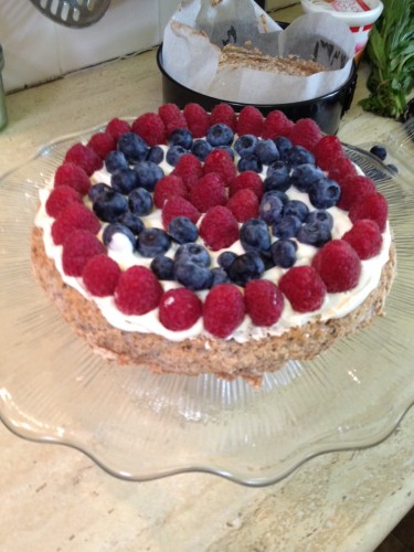 The bottom layer covered in cream and berries
