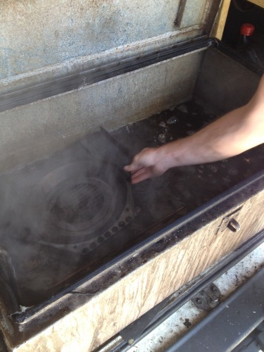 Matt putting the innards of my oven into the container of boiling water at the back of the Oven Express van