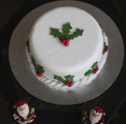 A Christmas Cake surrounded with holly