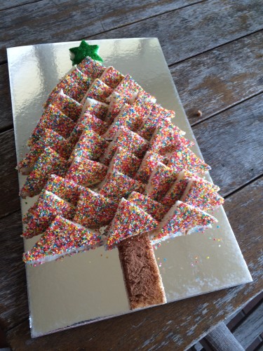 A fairy-bread Christmas tree.  The trunk is bread sprinkled with drinking chocolate.  The star is covered in shimmering green sprinkles.  