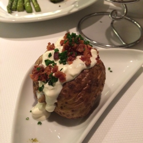 An Idaho jacket potato filled with sour cream, bacon and chives