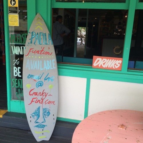 The entrance is beside the surfboard 