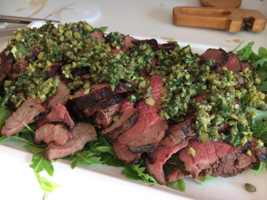 Eye fillet of beef on a bed of rocket with a dressing of cornichons, herbs and lemon juice