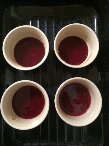 Raspberry jam and freshly squeezed orange juice sits at the bottom of the ramekins