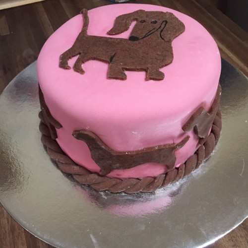 Cookie-cutter dachshunds glued to the sides of the cake