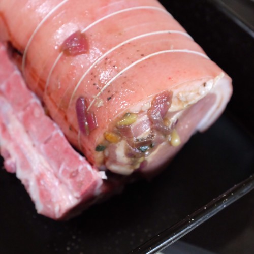 Pork loin on the roasting dish nestled on the bones